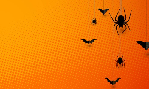 A orange pop art inspired background with black spiders and bats - it is halloween themed