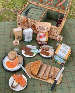 Image showing a picnic blanket with a selection of natural grain snacks with a picnic basket