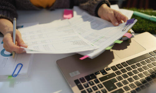 A close up of female hands holding pieces of paper work and looking at them