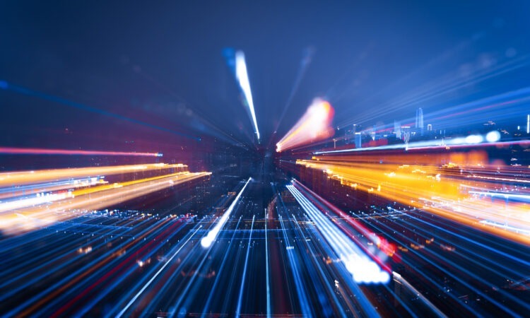 a dark night where the camera has caught lights and cars within a city, but it's blurred and out of focus.