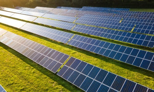 Solar Panels in line, in a green field capturing the sunshine